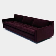 a purple couch sitting on top of a white floor