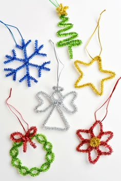 four christmas ornaments made out of string and bead on a white background with the word xo spelled in red, green, yellow and blue