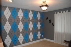 an empty room with blue and gray argyle wallpaper