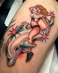 a woman is sitting on top of a dolphin with stars around her neck and legs