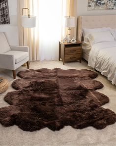 a bed room with a neatly made bed and a brown rug