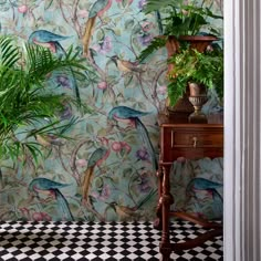 a wallpapered room with birds and plants on the side table next to a potted plant