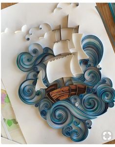 a paper cut out of a boat in the ocean with waves and clouds on it