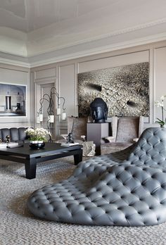 a living room filled with furniture and a large stone wall behind the couch is a coffee table