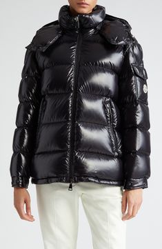 This hooded down puffer jacket crafted from glossy nylon is a contemporary take on an iconic Moncler design. A cockerel logo patch and engraved hardware bring signature touches to the look. Two-way front-zip closure Fixed hood Elastic cuffs Front zip pockets Lined, with down fill 100% polyamide Dry clean Imported Women's Designer Clothing Luxury Black Puffer Jacket With Detachable Hood, Designer Streetwear Puffer Jacket With Padded Collar, Luxury Black Duck Down Outerwear, Designer Winter Puffer Jacket For Streetwear, Black Luxury Puffer Jacket With Double-lined Hood, Luxury Black Puffer Jacket With Double-lined Hood, Designer Puffer Jacket With Padded Collar For Streetwear, Luxury Black Down Puffer Jacket, Designer Hooded Puffer Jacket With Padded Collar