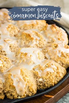 a skillet filled with cinnamon biscuits covered in icing and drizzled