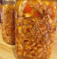 two jars filled with food sitting on top of a wooden table