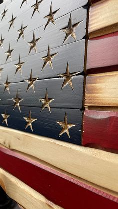 an american flag painted on top of a wooden bench with stars in the colors of red, white and blue