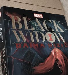 a book with the title black widow written in red and on top of it is an image of a spider - man