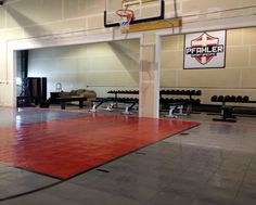 an indoor basketball court with gym equipment in the background