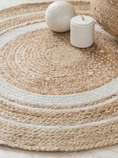 two white vases sitting on top of a rug