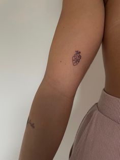 a woman's arm with a small tattoo on the left side of her body