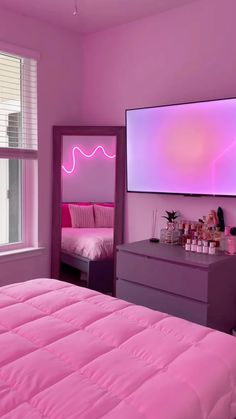 a bedroom with pink walls and purple bedding in front of a flat screen tv