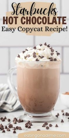 starbucks hot chocolate recipe in a glass mug with whipped cream and chocolate chips on top