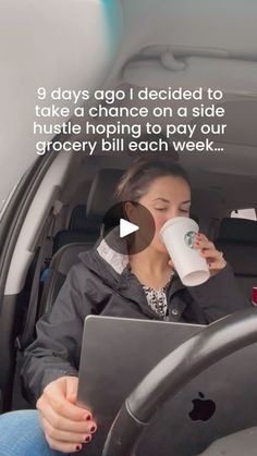 a woman sitting in the back seat of a car drinking from a coffee cup and using her laptop