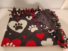 a blanket with hearts and paw prints on it