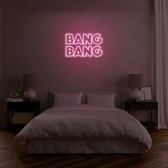 a bed in a room with a neon sign above it that says bang bang on the wall