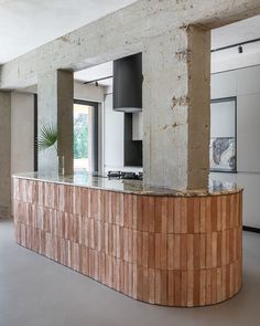 a kitchen with a counter top made out of bricks and concrete columns, in an unfinished room