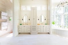 a large bathroom with double sinks and two mirrors