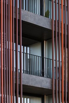 an apartment building with balconies and wooden slats on the outside, looking out onto the street