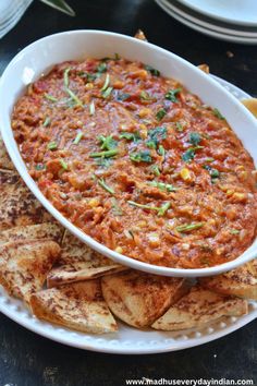 a white bowl filled with salsa and tortilla chips on top of a plate