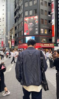 a man is walking down the street with his back to the camera