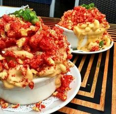 two white plates topped with pasta covered in sauce