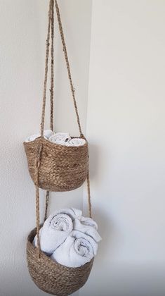 two baskets hanging from the wall with towels in them