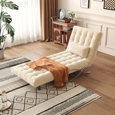 a white chaise lounge chair sitting on top of a rug in a living room