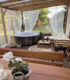 a hot tub sitting on top of a wooden deck next to a table and chairs