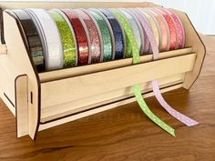 a wooden holder with various colored ribbons in it