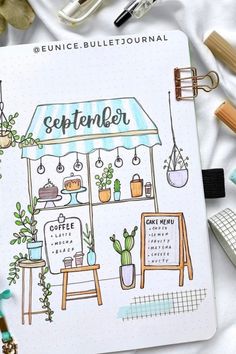 an open planner with potted plants and other items on the table next to it