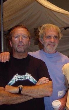 three men standing next to each other in front of a tent