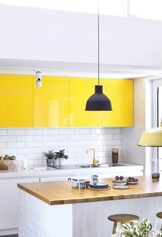 a kitchen with yellow cabinets and white countertops is seen in this image from the front view