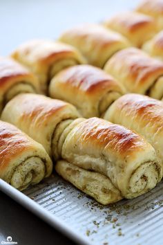 rolls are lined up on a baking sheet