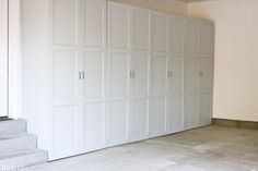 an empty room with white closets and stairs