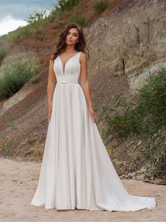 a woman in a wedding dress standing on the beach