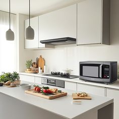 a kitchen with white cabinets and counter tops has a black microwave on the stove top