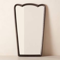 a mirror sitting on top of a table next to a wall