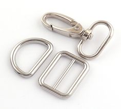 two metal buckles on a white background with one open and the other closed to reveal a rectangle shape