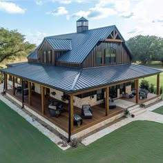 an aerial view of a large house with a metal roof and covered patio area in the foreground