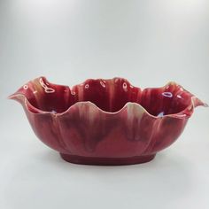 a red bowl sitting on top of a white table