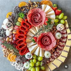 a platter filled with different types of cheeses and meats on top of each other