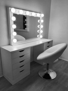 a white vanity with lights on it and a chair