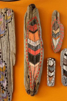 several native art pieces are hanging on the wall in front of an orange painted wall