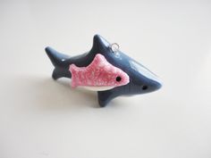 a blue and pink dolphin ornament sitting on top of a white table