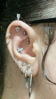 a close up of a person with ear piercings on their ears and behind the ear