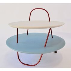 two tiered trays are stacked on top of each other with red metal handles