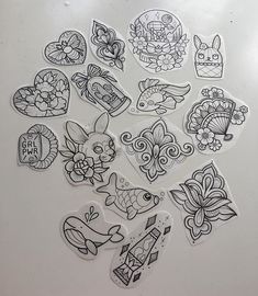 many different stickers are arranged on a white surface, including one with an image of animals and flowers