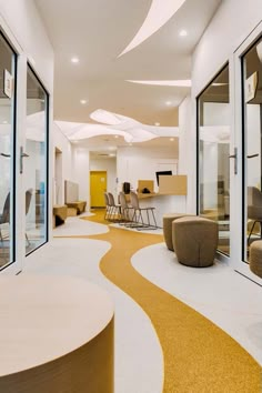 a room with chairs, tables and other furniture inside of it that is decorated in white and yellow